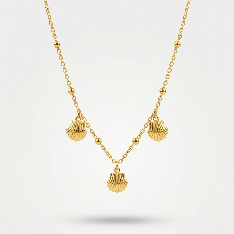 18kt gold plated shell charm necklace with three scallop shells floating on a white background.