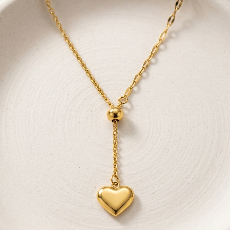 18kt gold plated sweetheart lariant necklace on a white plate.