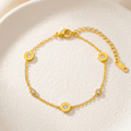 18kt gold plated, anti-tarnish chain bracelet with Roman numeral and crystal station charms on textured white plate.