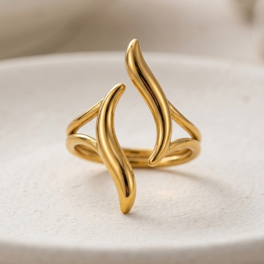 18kt gold plated ring with a wavy design on a white surface