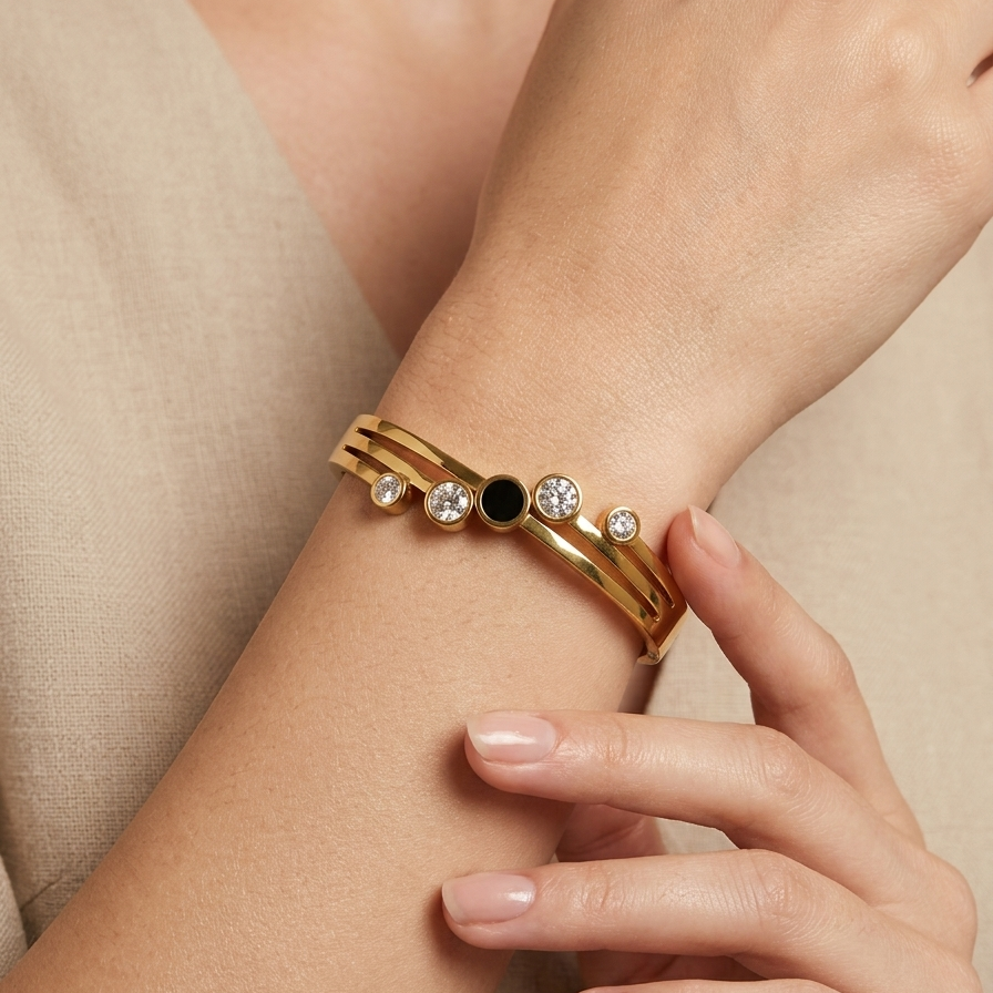 A woman model worn 18kt gold plated hinged bangle bracelet with black stone and crystal circles.