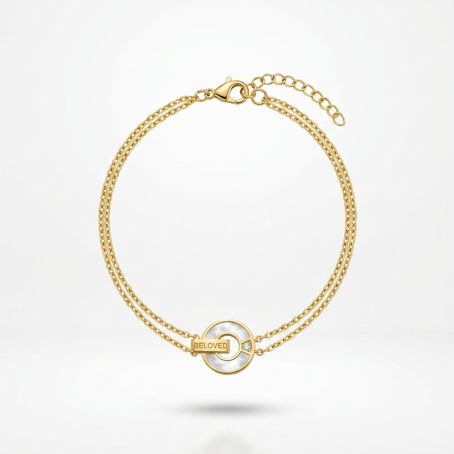 18kt gold plated, anti-tarnish "BELOVED" mother of pearl chain bracelet floating on white background.