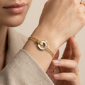 A Indian young woman model worn 18kt gold plated, tarnish free "BELOVED" mother of pearl bracelet on her wrist.