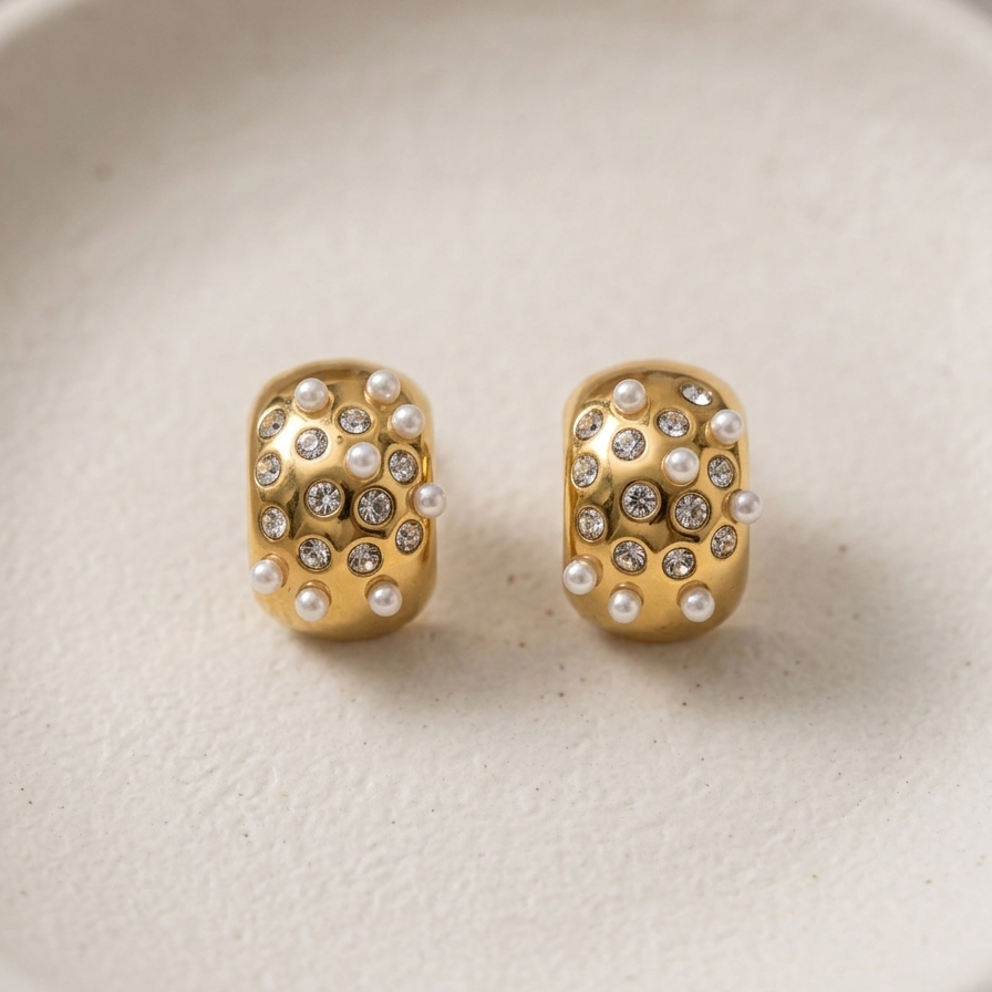 18kt gold plated, anti-tarnish hoops with embedded white pearls and crystals on textured off-white plate.
