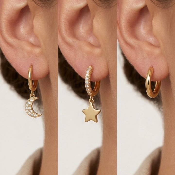 A model worn set of 18kt gold plated huggies with dangling star and moon charms on their ears.