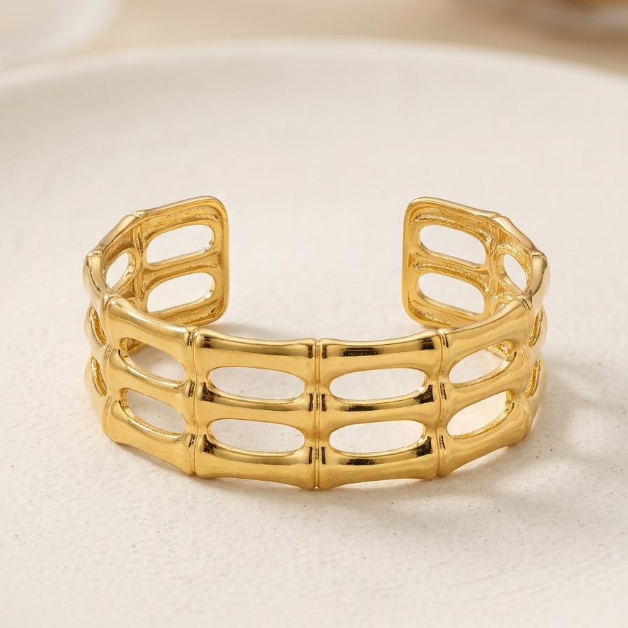 18kt gold plated, anti-tarnish gilded bamboo open cuff bracelet on off-white stone plate.