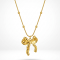 18kt gold plated 3D puffed bow pendant necklace floating on white background.