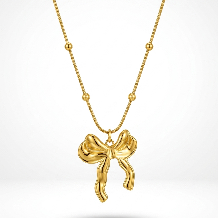 18kt gold plated 3D puffed bow pendant necklace floating on white background.