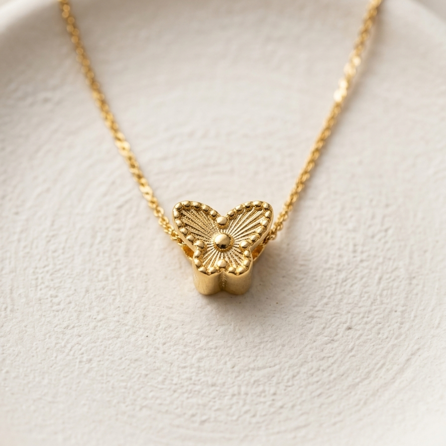 18kt gold plated necklace with a butterfly pendant on a white dish.