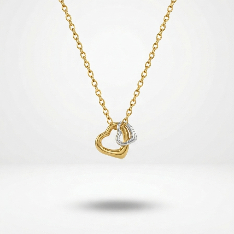 Gold necklace with a heart-shaped pendant on a white background