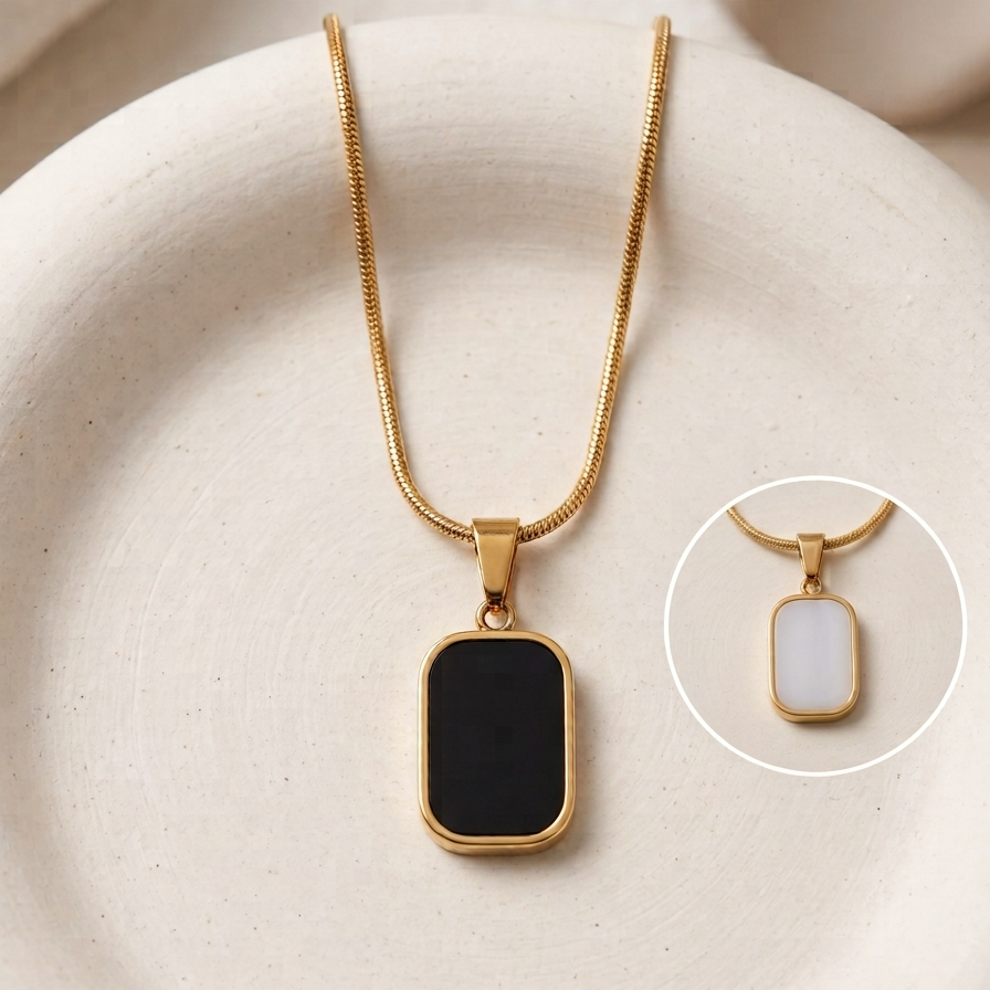 18kt gold plated reversible day and night pendant necklace showing both side on surface.