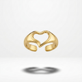 A gold adjustable ring with a heart-shaped cutout design in the center, shown floating against a clean white background with a soft shadow below.
