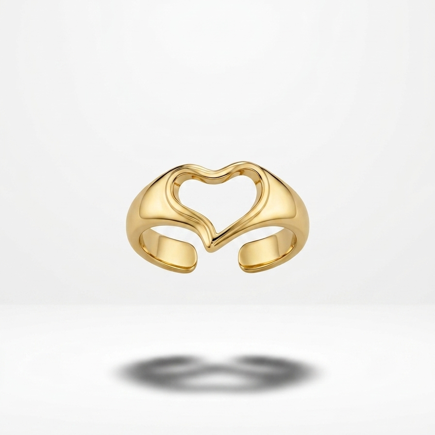 A gold adjustable ring with a heart-shaped cutout design in the center, shown floating against a clean white background with a soft shadow below.