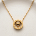 18k gold plated necklace featuring a circular pendant engraved with Roman numerals and a spinning inner barrel accented with CZ diamonds.