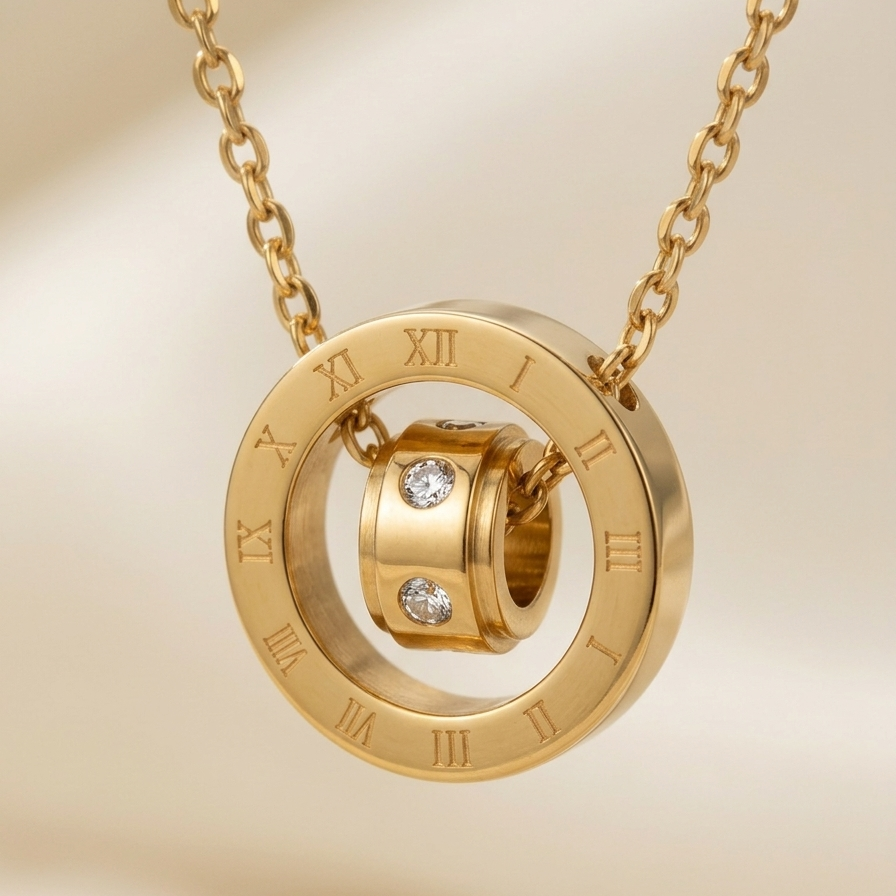 Close up of a 18k gold plated necklace featuring a circular pendant engraved with Roman numerals and a spinning inner barrel accented with CZ diamonds.