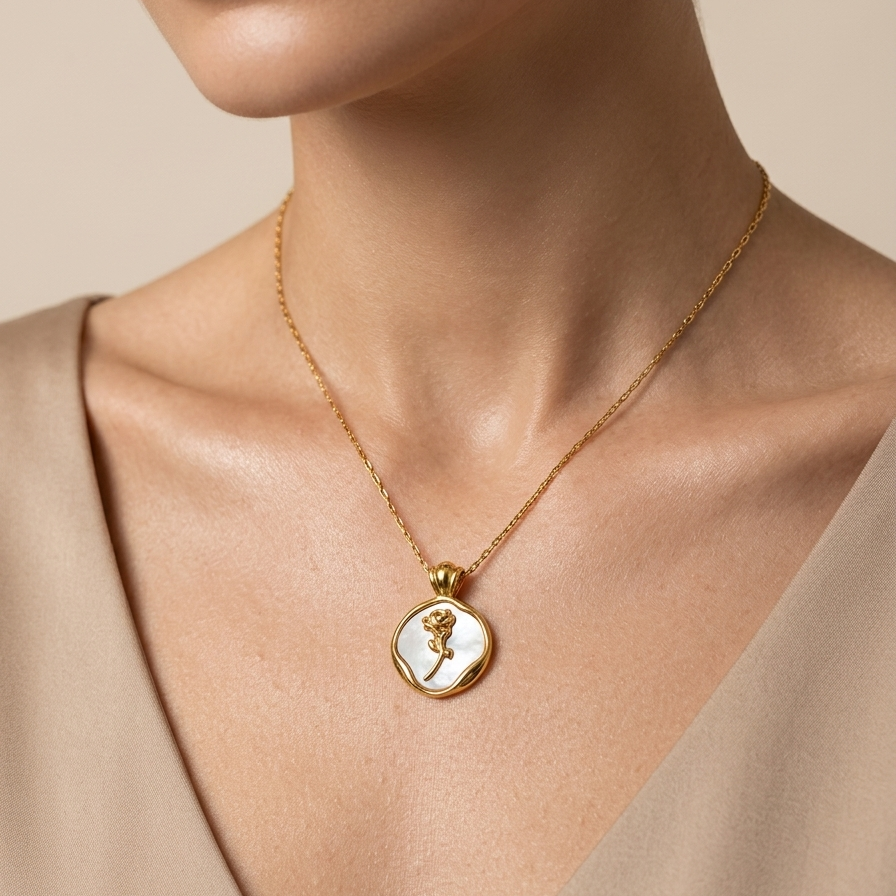 18k gold plated medallion necklace featuring a mother of pearl inlay and a raised golden rose motif in the center worn by a model against a neutral background