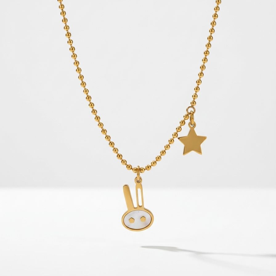 18k gold plated beaded chain necklace featuring a minimalist bunny charm with pearl inlay and a small golden star charm.