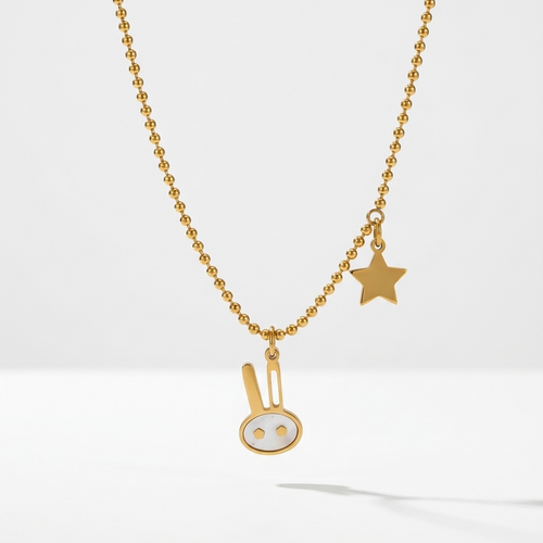 18k gold plated beaded chain necklace featuring a minimalist bunny charm with pearl inlay and a small golden star charm.