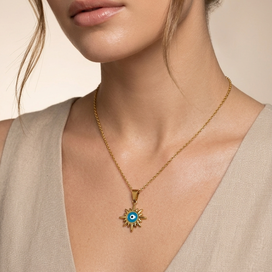 Woman wearing a 18k gold plated necklace featuring a radiant sunburst pendant with a classic blue and white enamel evil eye in the center.