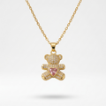 18k gold plated teddy bear pendant necklace fully encrusted with clear CZ diamonds, featuring a pink heart-shaped crystal in the center.