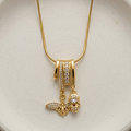 18k gold plated necklace featuring an intricate diamond-encrusted sliding bail holding a detailed golden bee charm and a small figure charm.
