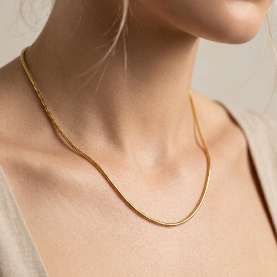 18k gold plated foxtail layering chain showing intricate woven V-shaped links and an adjustable extender clasp worn by a person with a neutral background