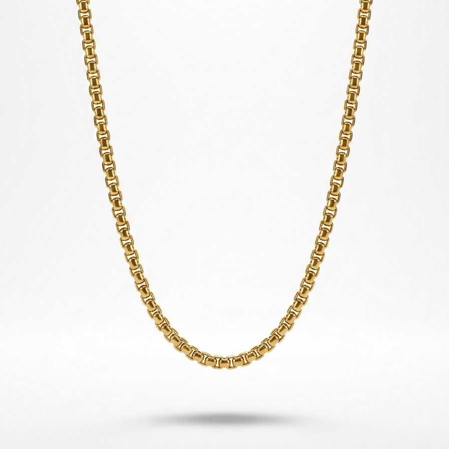 A gold chain necklace with a classic curb link design, suspended against a clean white background with a soft shadow underneath.