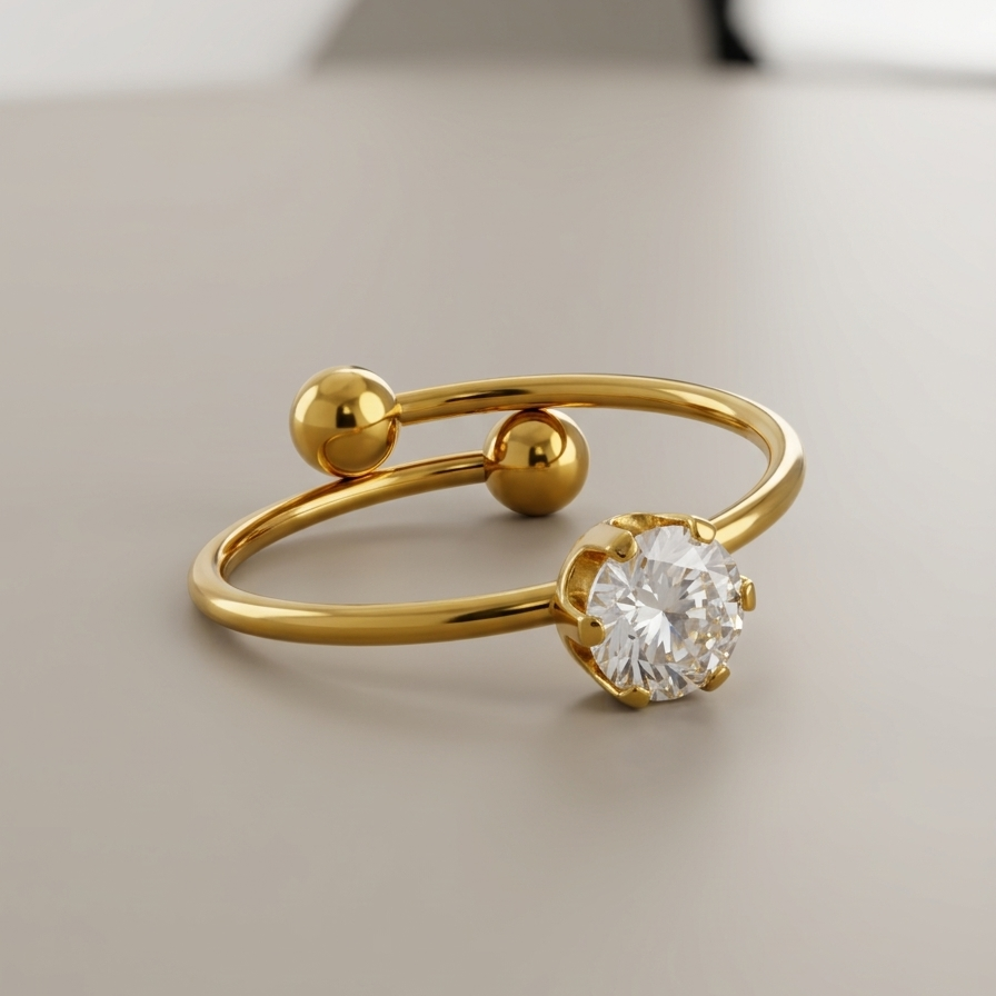 an 18k gold plated minimalist adjustable ring featuring a single CZ diamond and two small gold spheres, resting on a clean grey surface.