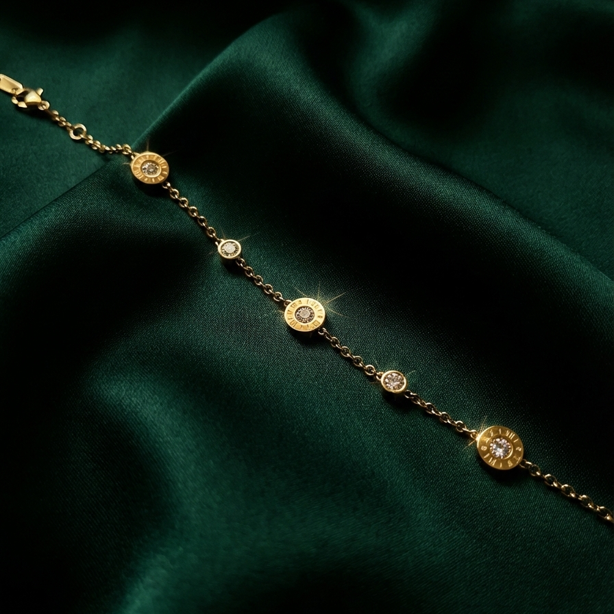 Gold chain bracelet with Roman numeral and crystal station charms on jewelry box.