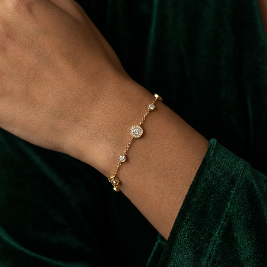 Gold chain bracelet with Roman numeral and crystal station charms on jewelry box.