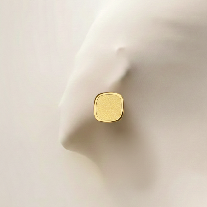 Square gold stud earrings with matte brushed texture and polished rim on white surface.