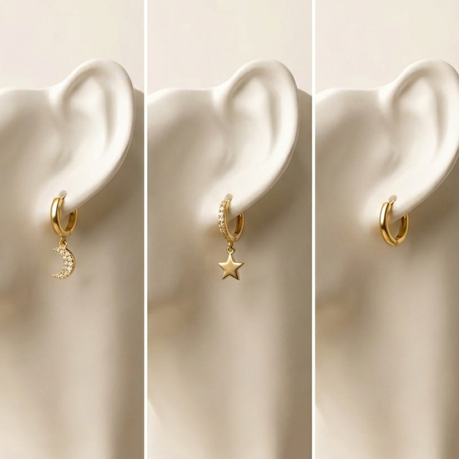 Set of gold huggie earrings with dangling star and moon charms on packaging card.