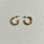 Pair of chunky gold tube hoop earrings on white background.