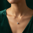 Single round crystal solitaire pendant necklace on white fabric background.