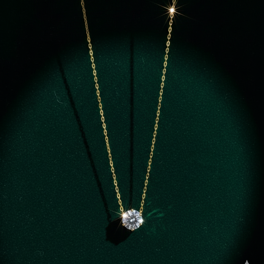 Single round crystal solitaire pendant necklace on white fabric background.