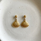 Gold shell drop earrings with scallop charm on white packaging card