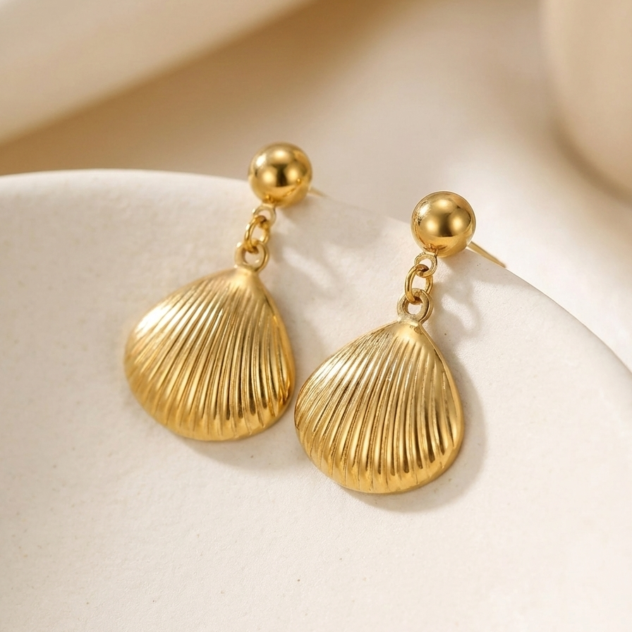 Gold shell drop earrings with scallop charm on white packaging card