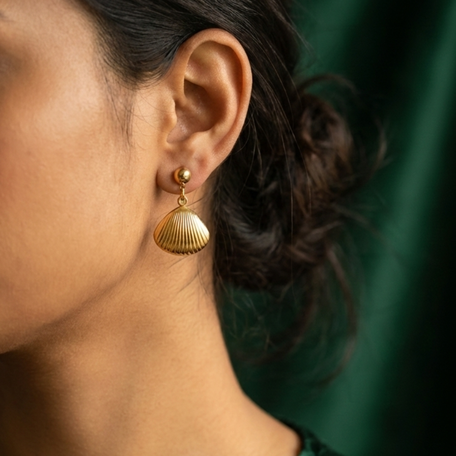 Gold shell drop earrings with scallop charm on white packaging card