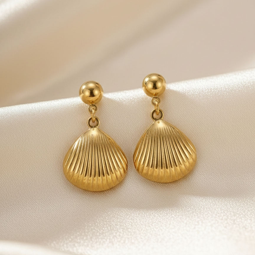 Gold shell drop earrings with scallop charm on white packaging card