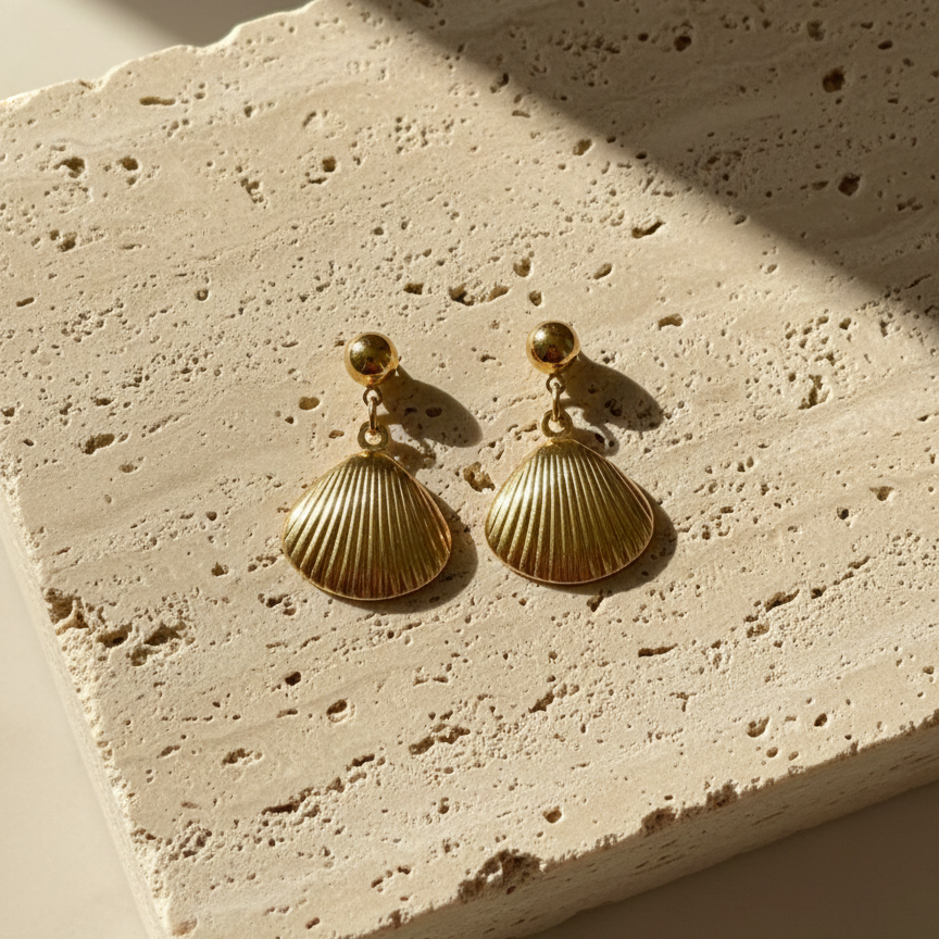 Gold shell drop earrings with scallop charm on white packaging card