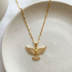 Gold dove pendant necklace with crystal zirconia wings in beige jewelry box packaging.