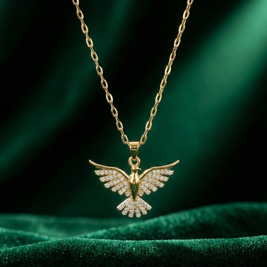 Gold dove pendant necklace with crystal zirconia wings in beige jewelry box packaging.
