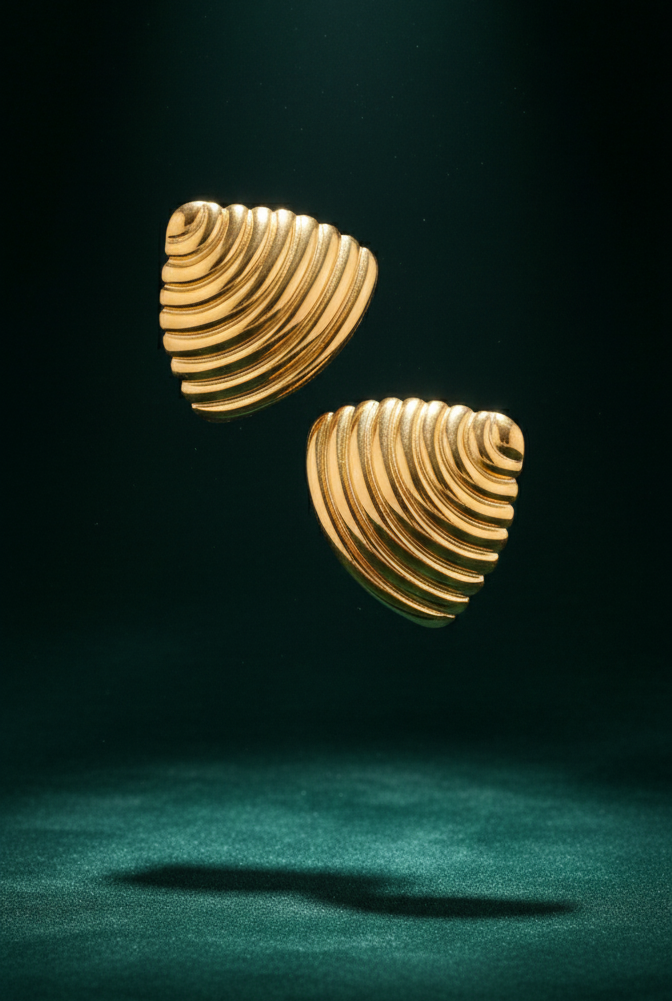 Ribbed gold croissant style triangular stud earrings on white background.