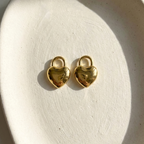 Gold puffy heart padlock earring worn on ear model.
