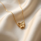 Small gold butterfly pendant with textured wings on white plate.