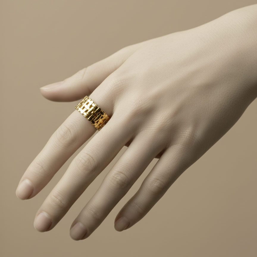 Wide gold ring with woven basket weave texture on white background.