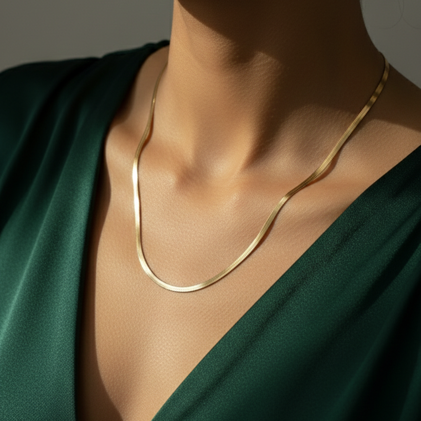 Flat gold herringbone snake chain necklace liquid gold texture waterproof 18k plated on beige silk.