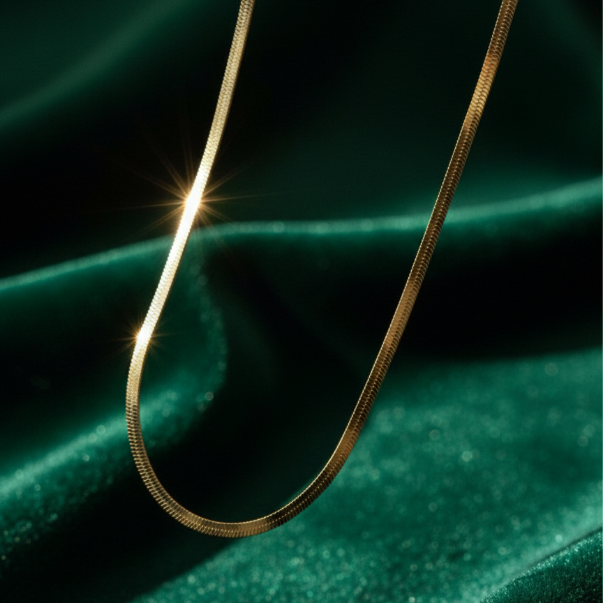 Flat gold herringbone snake chain necklace liquid gold texture waterproof 18k plated on beige silk.