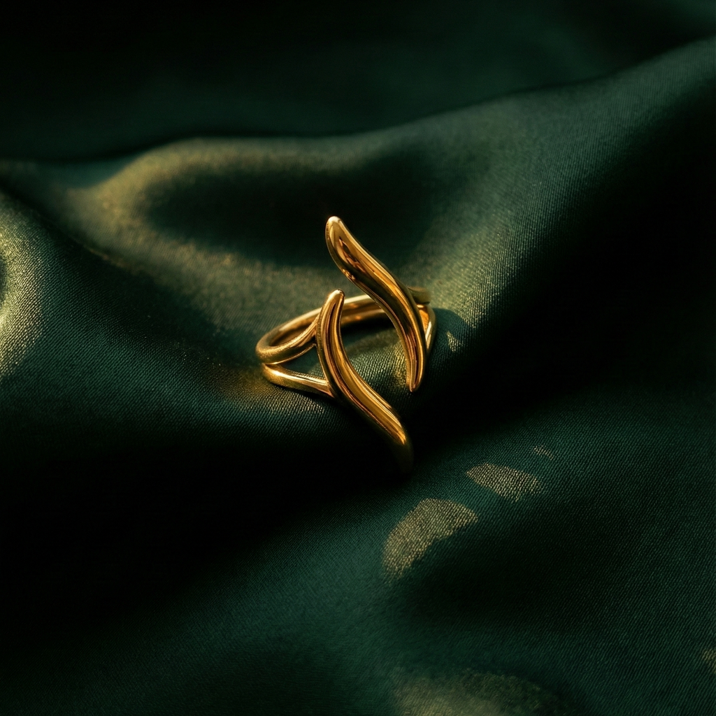 Gold wave ring with open adjustable design on white stone background.