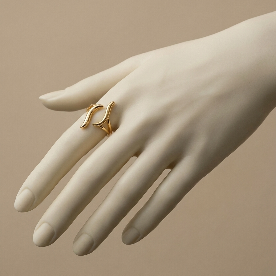 Gold wave ring with open adjustable design on white stone background.